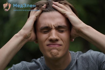 Мужчина держится за голову от боли